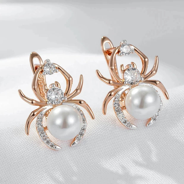 Spider-shaped earrings with pearls and gemstones on a white background