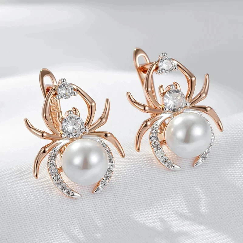 Spider-shaped earrings with pearls and gemstones on a white background