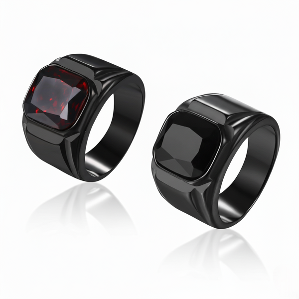 Two black rings with a red gemstone on a white background