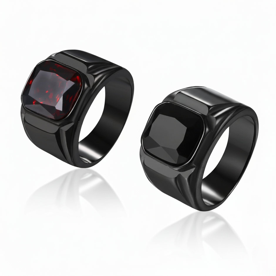 Two black rings with a red gemstone on a white background
