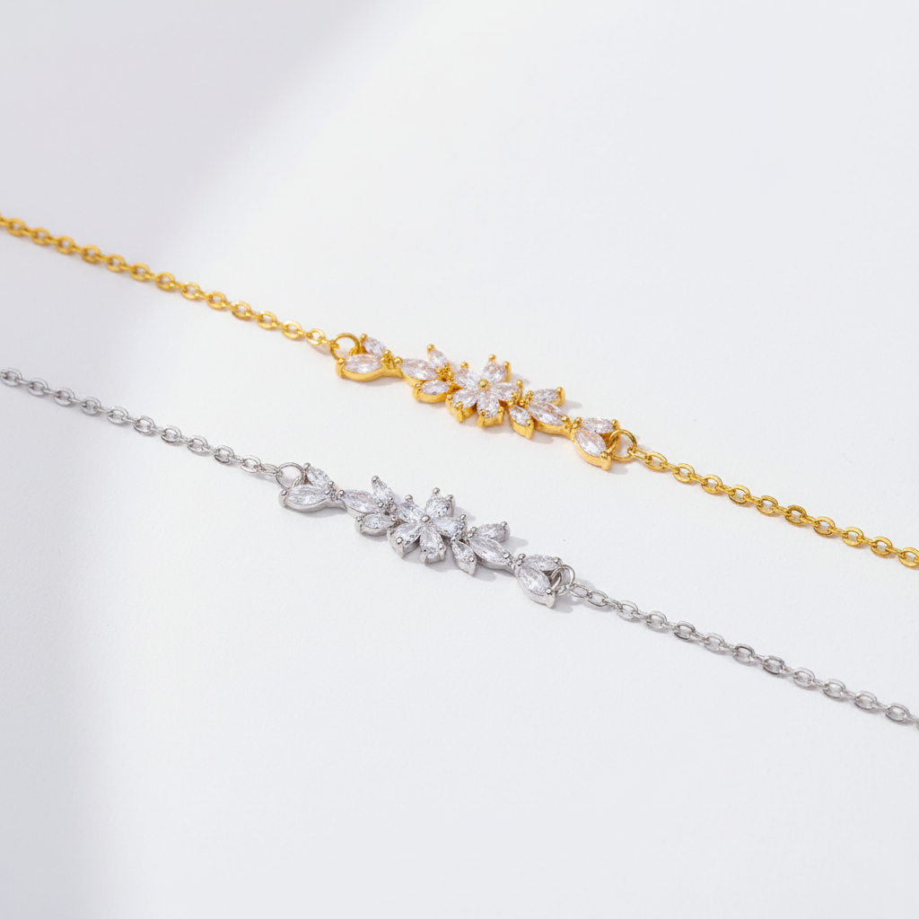 Two gold and silver bracelets with floral designs on a light gray background