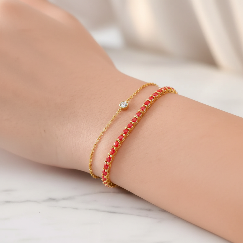 Two bracelets on a wrist against a marble background