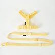Yellow dog harness and leash set on a white background