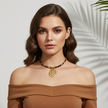 Woman wearing a gold necklace against a neutral background