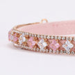 Pink compact mirror with decorative gemstone border on a light background