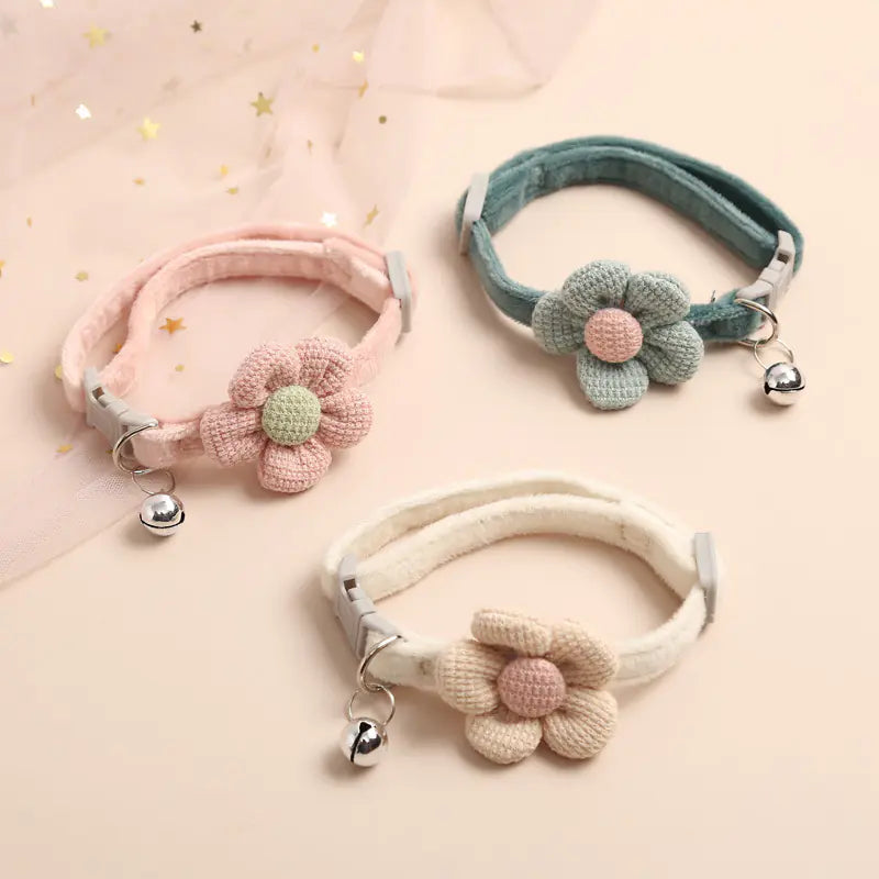 Three decorative dog collars with floral designs on a light pink background