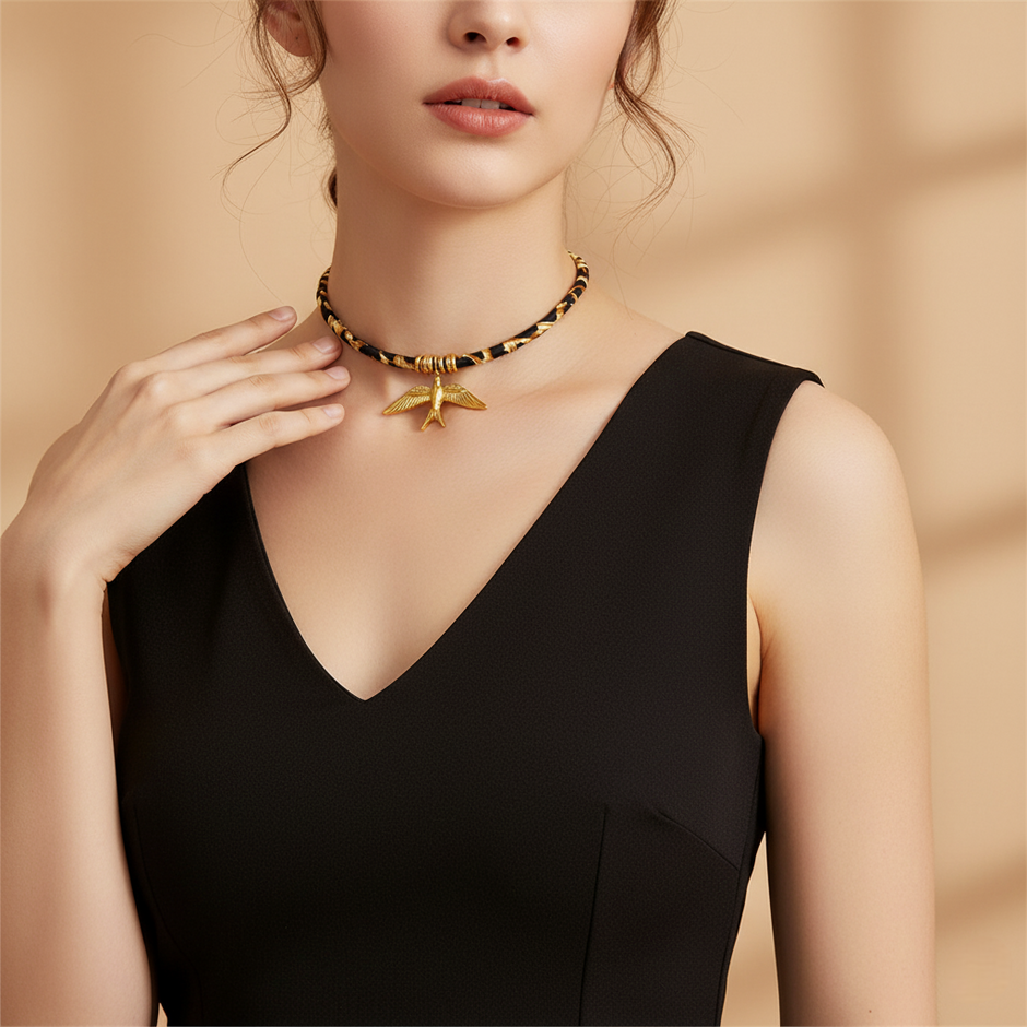 Woman wearing a black dress and gold necklace against a beige background