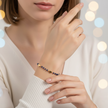 Woman wearing a blue beaded bracelet with a blurred bokeh background