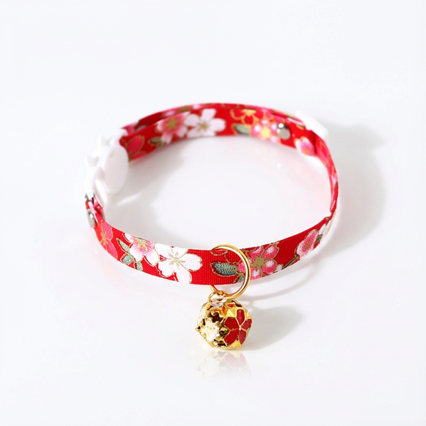 Red floral-patterned cat collar with a gold bell on a white background
