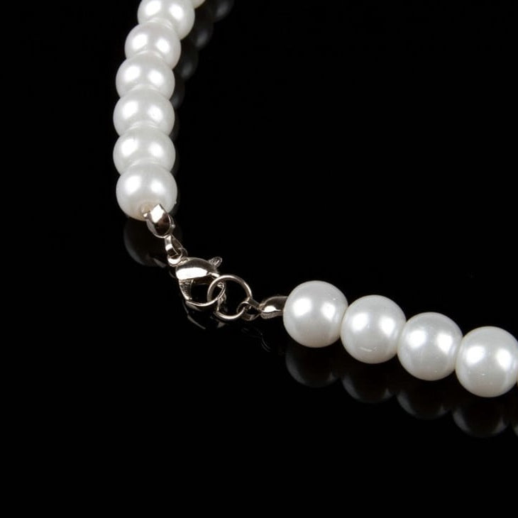Pearl necklace with a silver clasp on a black background