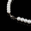 Pearl necklace with a silver clasp on a black background