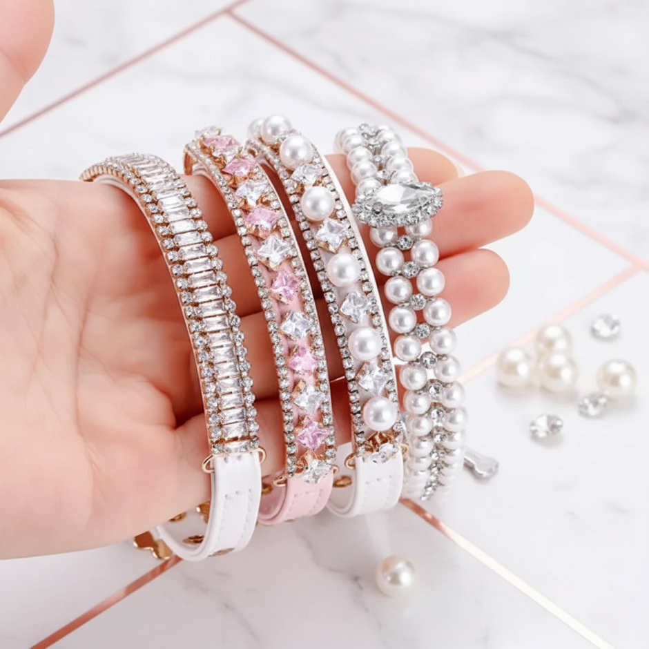 Hand holding four pearl and crystal collars on a light background