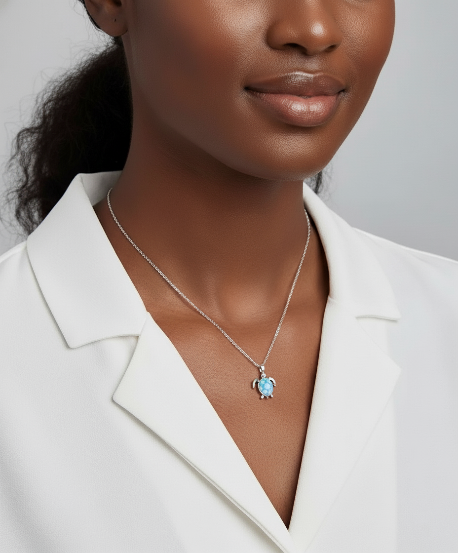 Woman wearing a necklace with a blue turtle against a neutral background
