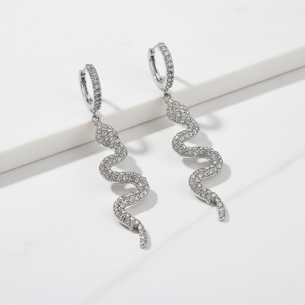 Silver snake-shaped earrings on a white background