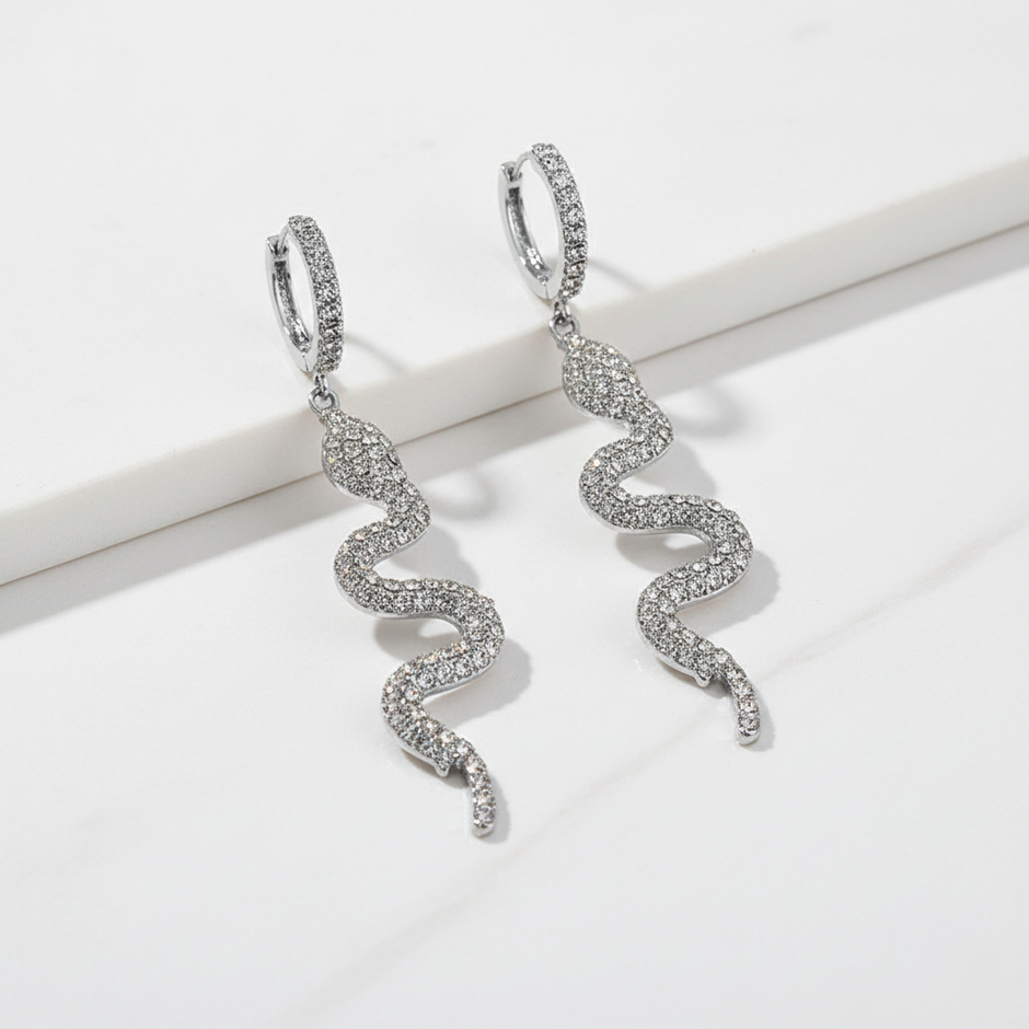 Silver snake-shaped earrings on a white background