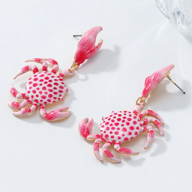 pair of red and white enamel crab dangle earrings on a white background
