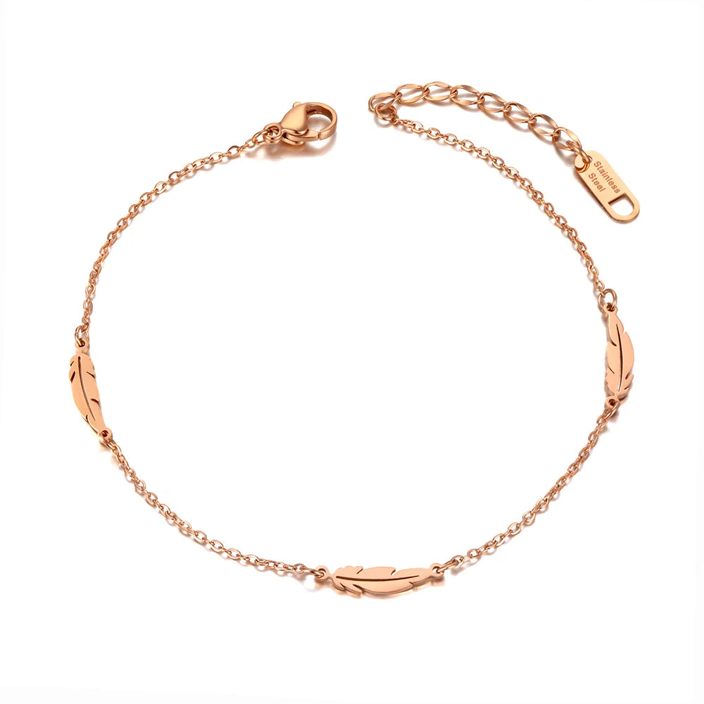 Rose gold anklet with feather designs on a white background