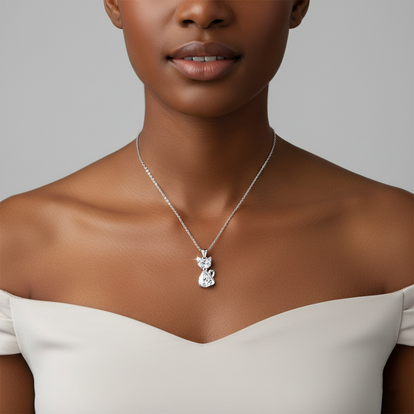 Woman wearing a silver necklace with a pendant against a neutral background