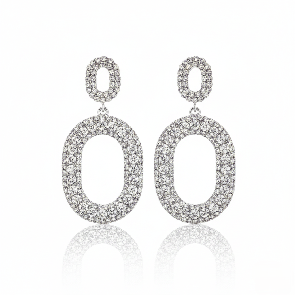 Pair of silver oval earrings with clear stones on a white background