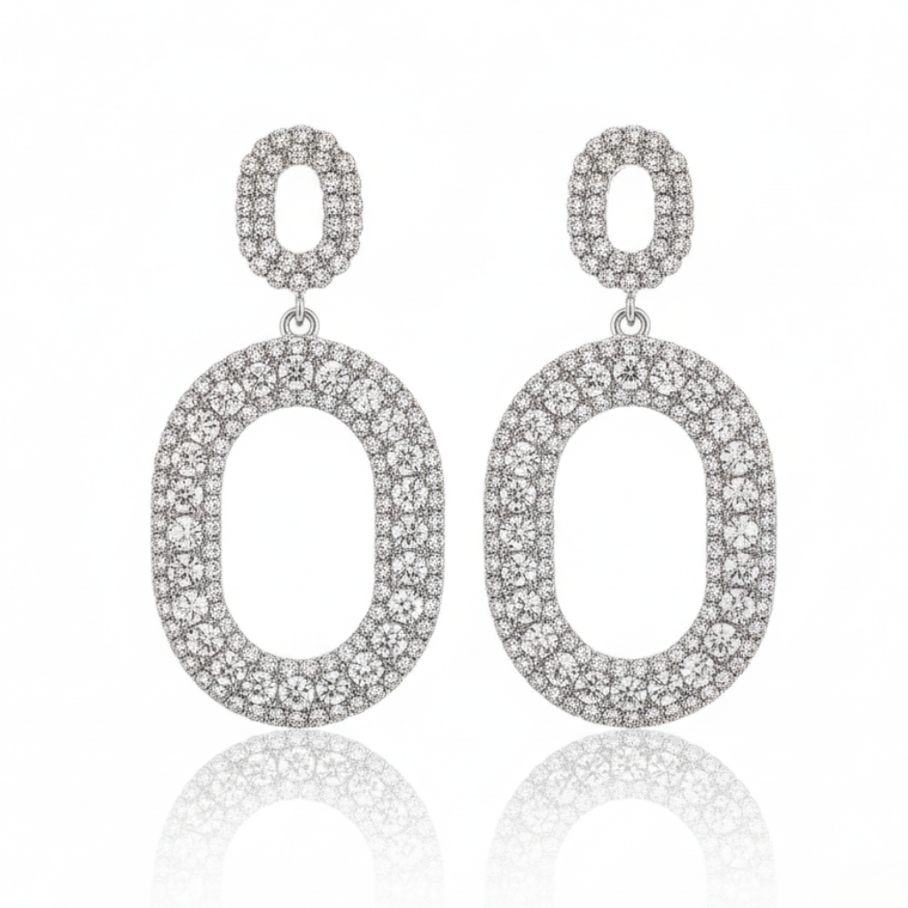 Pair of silver oval earrings with clear stones on a white background