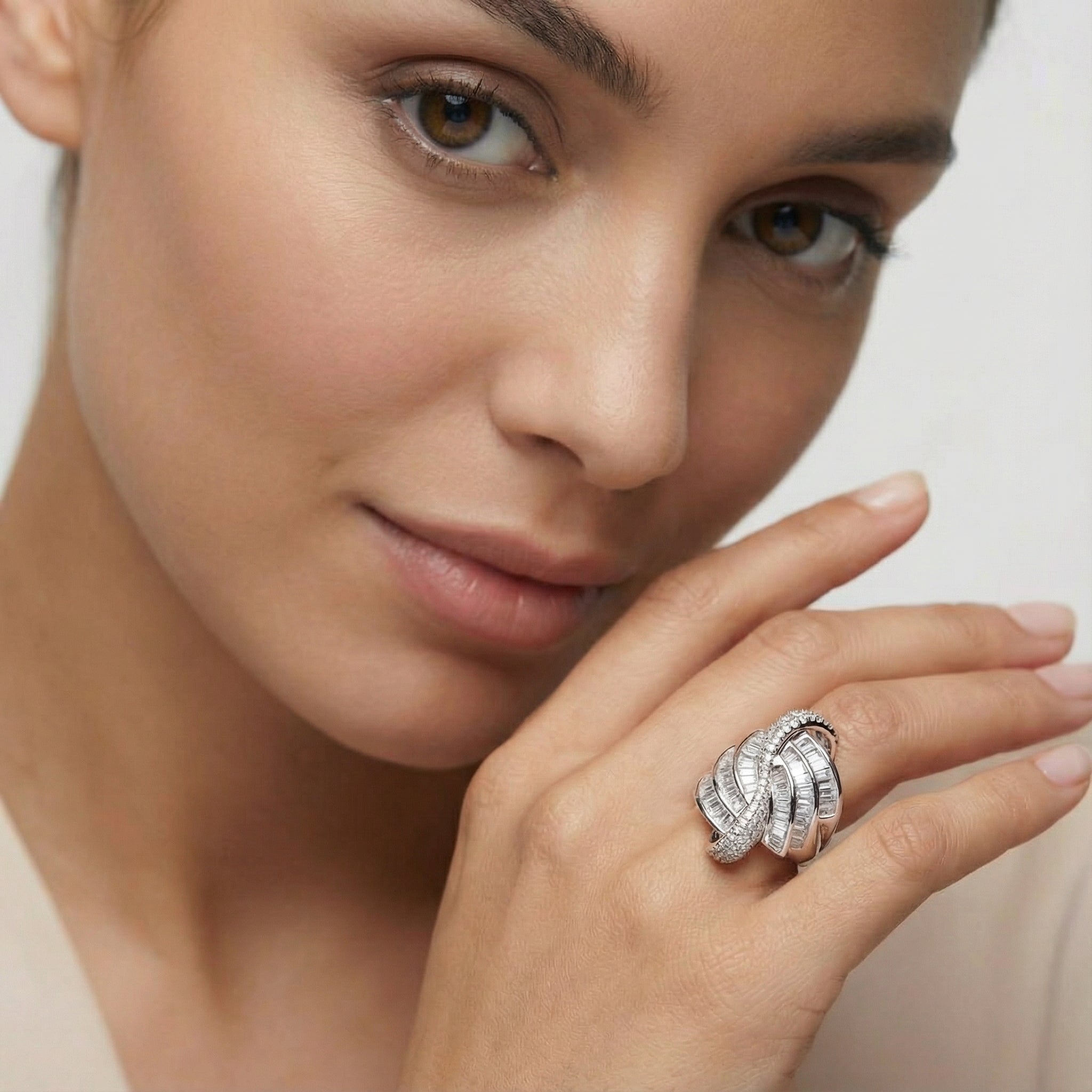 Close-up of a woman's hand wearing a silver ring with a white background