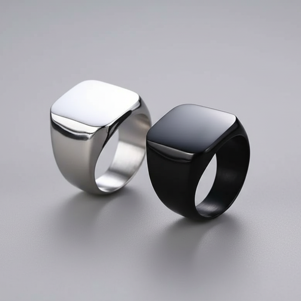 Two rings, one silver and one black, on a gray background