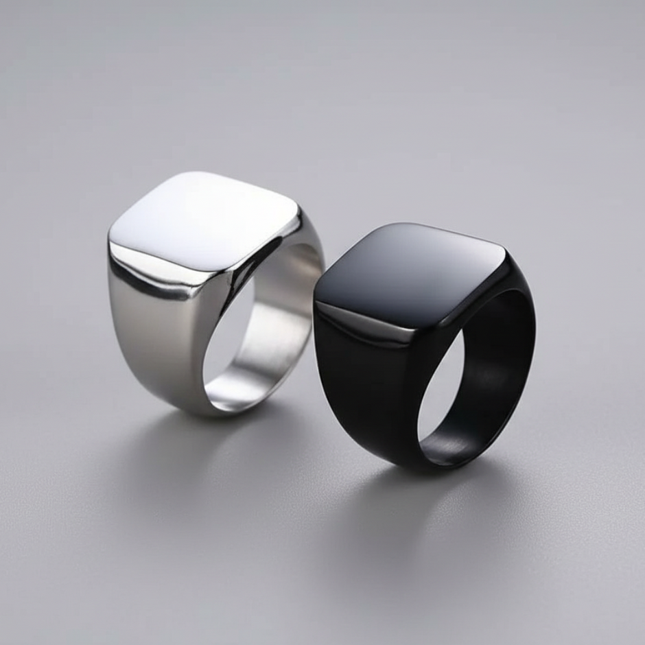 Two rings, one silver and one black, on a gray background