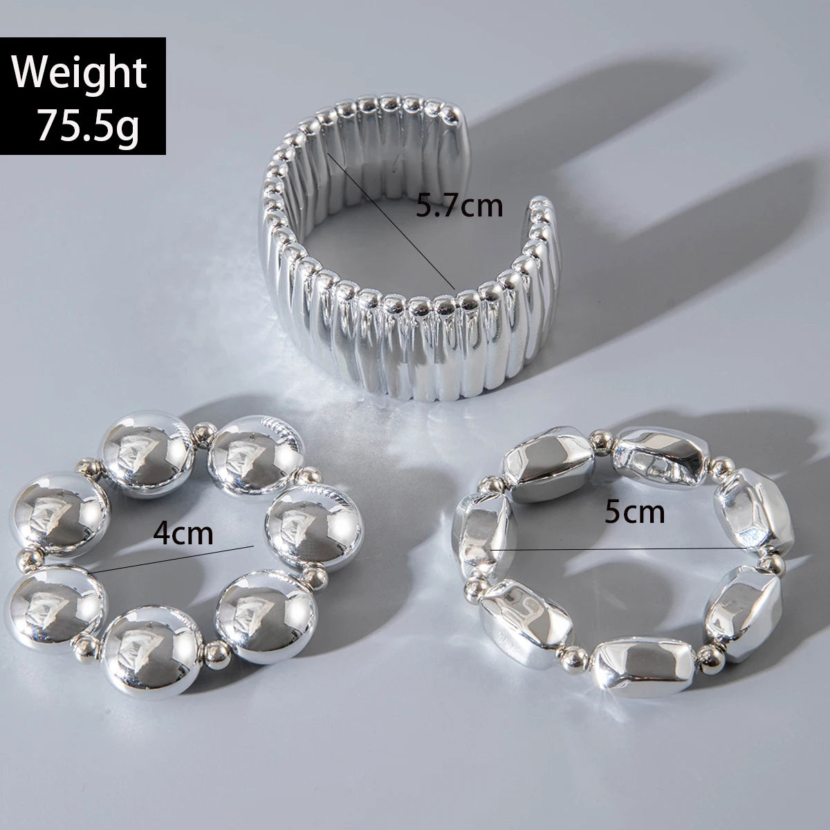 Silver bangle with measurements on a light gray background